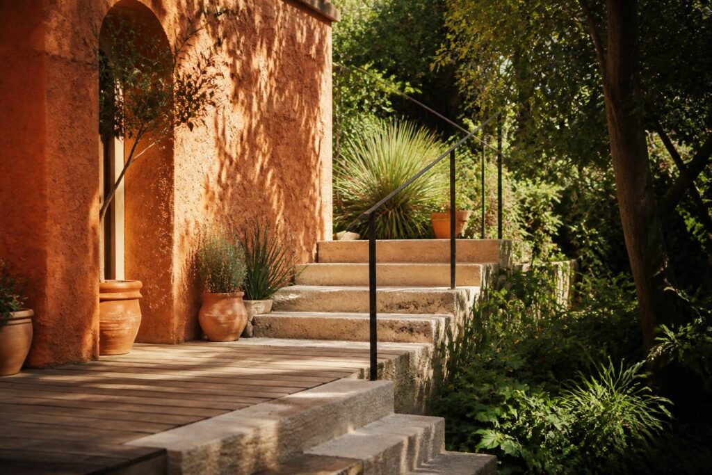 Escalier extérieur en pierre avec garde-corps entre terrasse et jardin