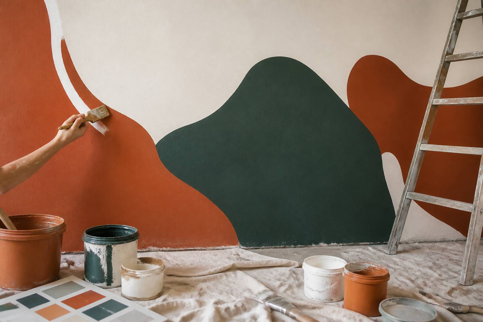 Mains peignant une fresque murale avec un pinceau sur un mur